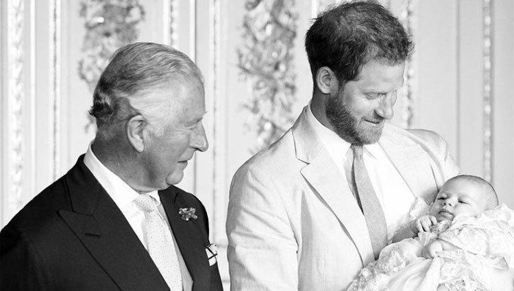 El Príncipe Carlos y el Príncipe Harry miran a Archie en su bautizo