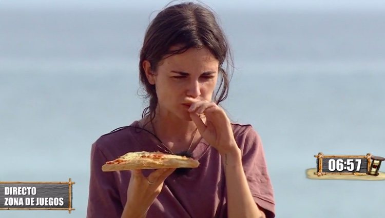 Alexia se come un trozo de pizza ante la mirada de sus compañeros / Foto: telecinco.es