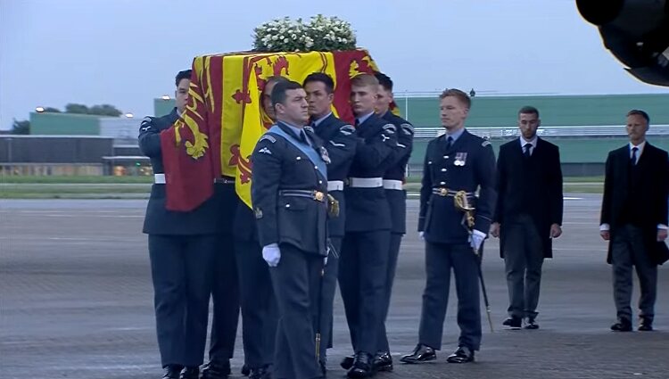 El féretro de Isabel II es descendido del avión tras su aterrizaje en Londres