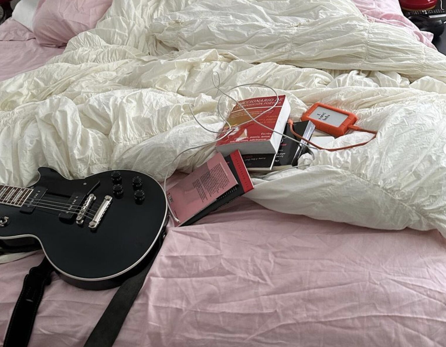 La cama revuelta de Rosalía con el libro rojo encima/ Foto: Instagram