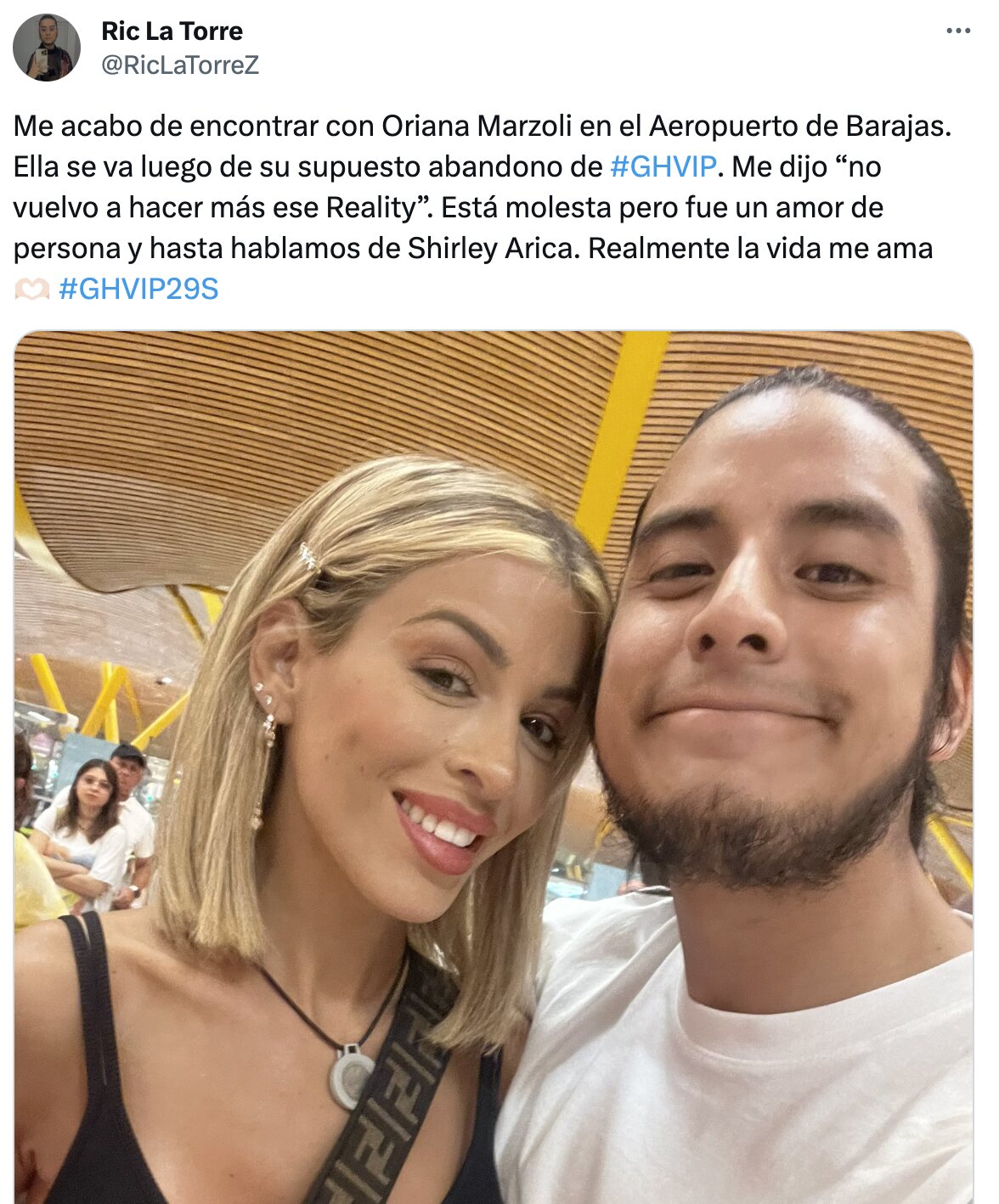 Oriana con un fan en el aeropuerto de Madrid con el imán del micrfóno todavía al cuello | Foto: Twitter