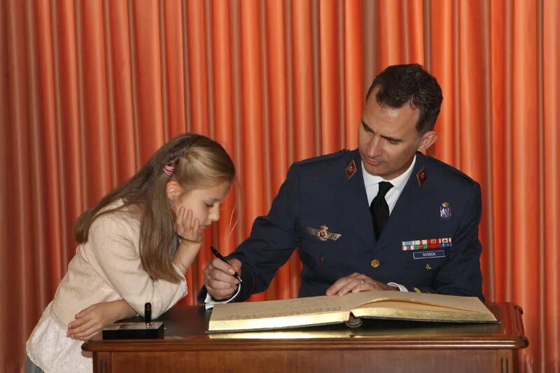Doña Leonor observa cómo Don Felipe firma en el libro de honor de la Academia de San Javier