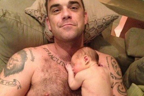 Robbie Williams con su primera hija, Theodora apoyada en su pecho