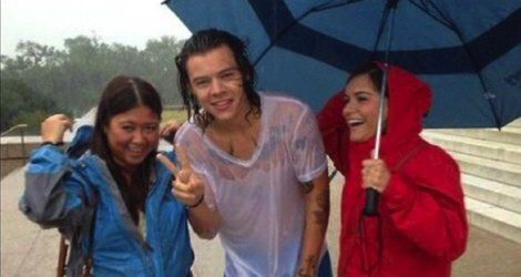 Harry Styles con sus fans compartiendo un paraguas / Instagram