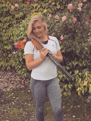 Amber Hill junto a la escopeta con la competirá en Río 2016