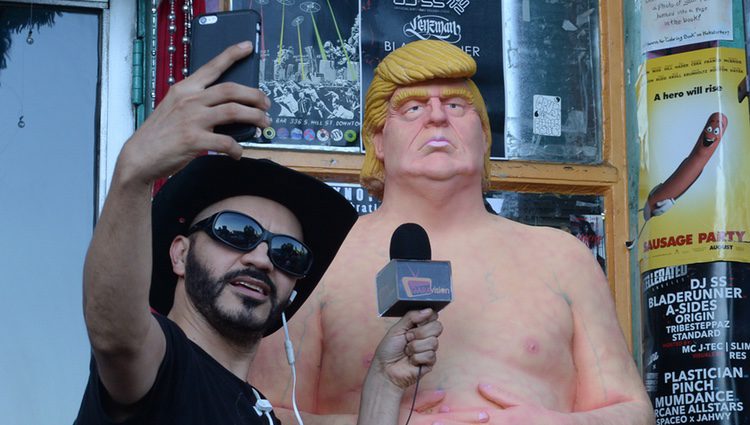 Periodista posando con la estatua de Donald Trump