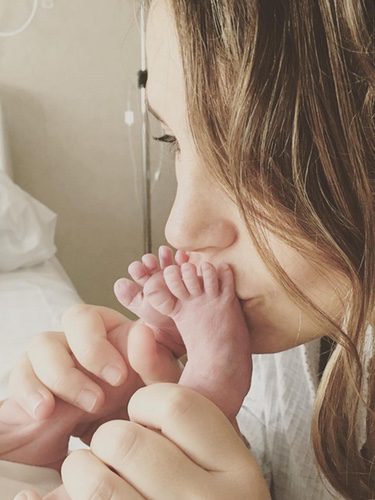 Nira Juanco besando los piececitos de su hija / Instagram