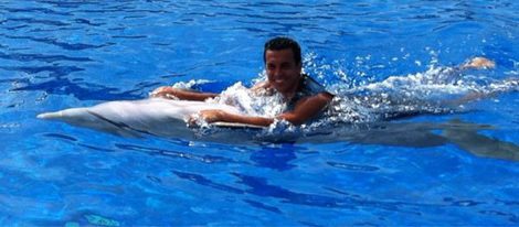 Pedro bañándose con un delfín
