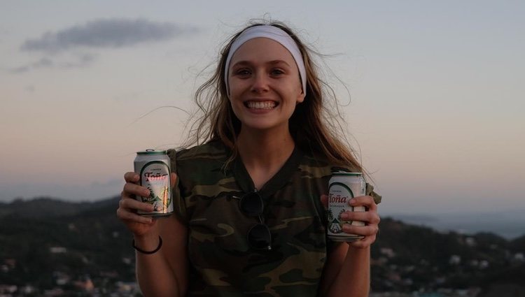 Elizabeth Olsen sonriente con dos cervezas