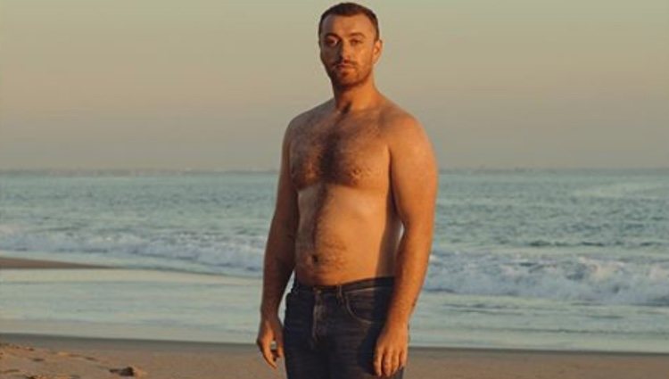 Sam Smith posando en la playa con el torso descubierto