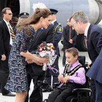 Un niño entrega un ramo flores a Catalina Middleton a su llegada a Canadá