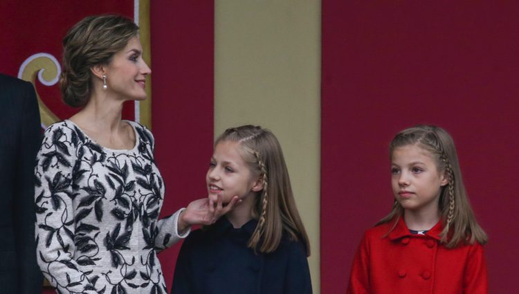 La Reina Letizia hace una carantoña a la Princesa Leonor junto a la Infanta Sofía en el Día de la Hispanidad 2016
