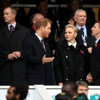 El Príncipe Harry charlando con Charlene de Mónaco y Gareth Wittstock en un partido de rugby