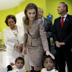 La Reina Letizia acaricia a una niña en presencia de Rita Barberá