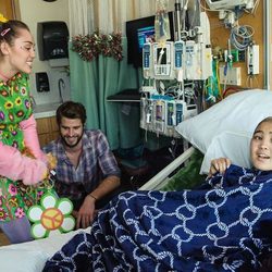 Miley Cyrus y Liam Hemsworth junto a una enferma en el hospital infantil