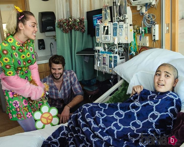 Miley Cyrus y Liam Hemsworth junto a una enferma en el hospital infantil