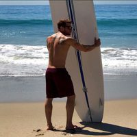 Ryan Phillippe sostiene una tabla de surf