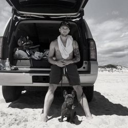 Ryan Phillippe en la playa apoyado sobre un coche