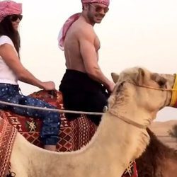 Zac Efron montando en camello con una amiga en Dubái