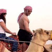 Zac Efron montando en camello con una amiga en Dubái