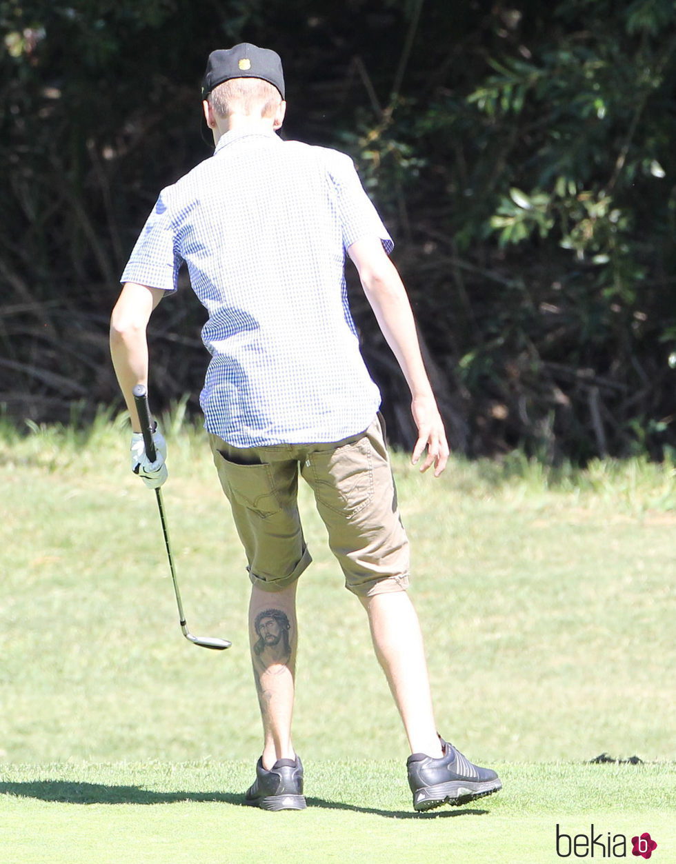 Justin Bieber jugando a golf y enseñando su tatuaje de Cristo
