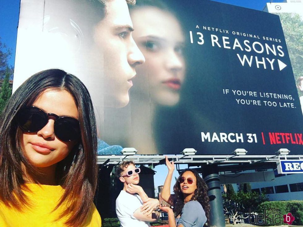 Selena Gomez, Tommy Dorfman y Alisha Boe delante del cartel de 'Por 13 razones'