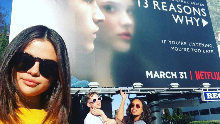 Selena Gomez, Tommy Dorfman y Alisha Boe delante del cartel de 'Por 13 razones'
