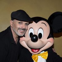 Miguel Bosé posando al lado de Mickey Mouse