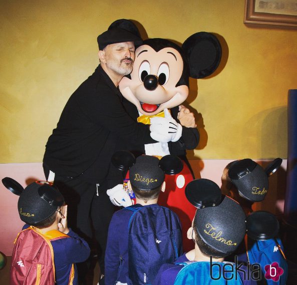 Miguel Bosé abrazando a Mickey Mouse con sus cuatro hijos