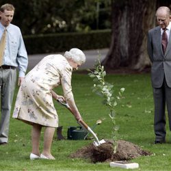 La Reina Isabel planta un árbol mientras el Duque de Edimburgo le observa