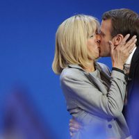 Emmanuel y Brigitte Macron besándose en una acto público