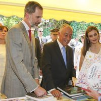 Los Reyes Felipe y Letizia con el presidente de Portugal mirando libros en la inauguración de la Feria del Libro 2017