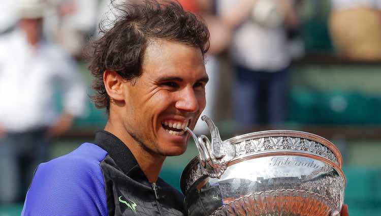 Rafa Nadal mordiendo el trofeo de campeón de Roland Garros 2017