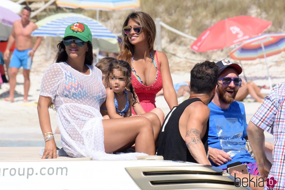 Leo Messi, Cesc Fábregas, Antonella Roccuzzo, Daniella Semaan y Lia Fábregas en un yate a orillas de una playa de Formentera