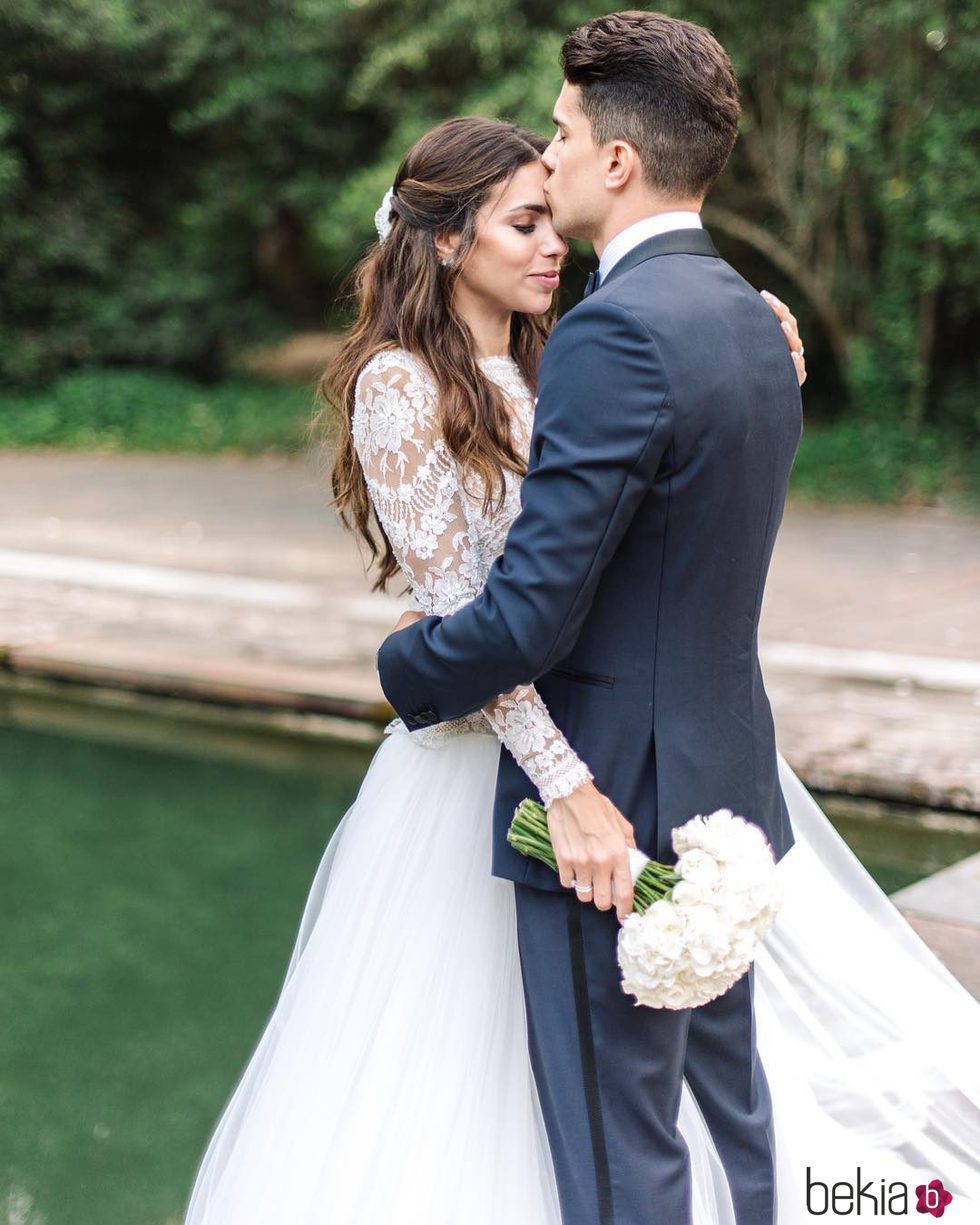 Marc Bartra besando en la frente a Melissa Jiménez en su boda