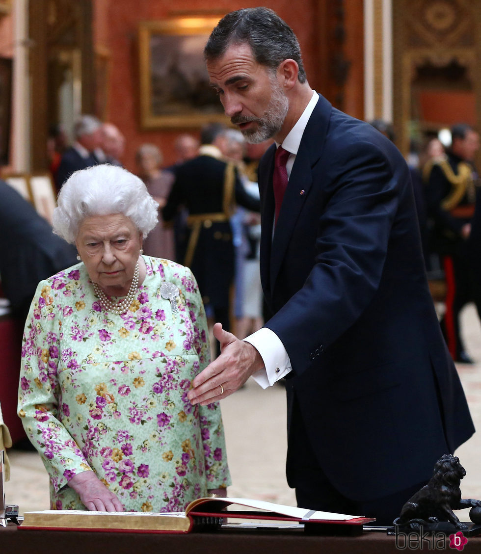 El Rey Felipe y la Reina Isabel durante la visita a unos objetos españoles en Buckingham Palace