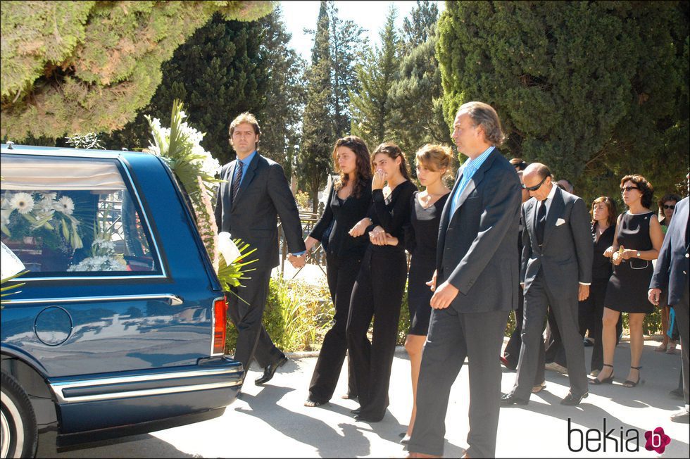 Bertín junto a sus hijas en el funeral de Sandra Domecq