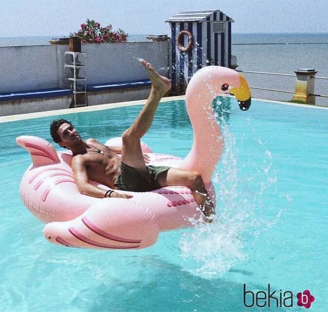 Beltrán Lozano en bañador con un flamenco rosa en la piscina