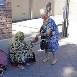 La madre de Antonio Carmona da limosna a una mujer tras visitar a su hijo en el hospital