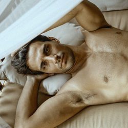 Jaime Astrain tumbado en la cama sin camiseta