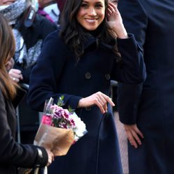 Meghan Markle sonriente en su primer acto público tras el compromiso con el Príncipe Harry