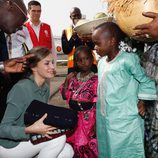 La Reina Letizia recibe unos regalos de unos niños en su despedida de Senegal