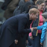 El Príncipe Harry saluda a un niño durante su visita oficial a Gales con Meghan Markle