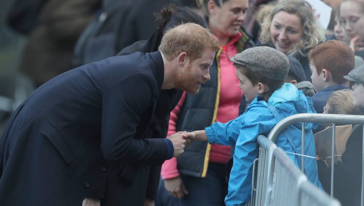 El Príncipe Harry saluda a un niño durante su visita oficial a Gales con Meghan Markle