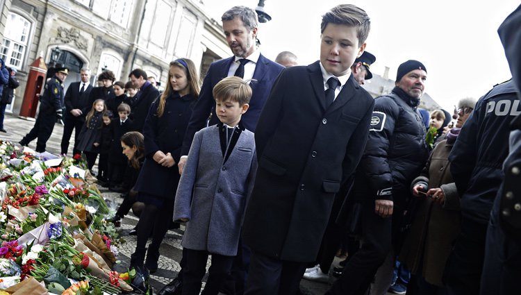 Los hijos, las nueras y los nietos de Enrique de Dinamarca miran los recuerdos colocados en su honor en Amalienborg