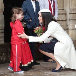 Meghan Markle se agacha para hablar con una niña en el Día de la Commonwealth 2018