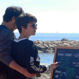Chino Darín y Úrsula Corberó mirnado un menú en la playa de Málaga
