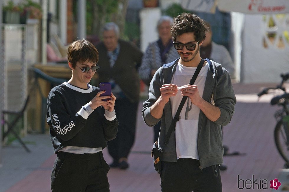 Úrsula Corberó u Chino Darín irando sus móviles mientras pasean por Málaga