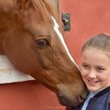 Isabel de Dinamarca feliz junto a un caballo en su onceavo cumpleaños