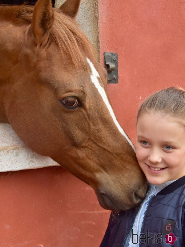 Isabel de Dinamarca feliz junto a un caballo en su onceavo cumpleaños